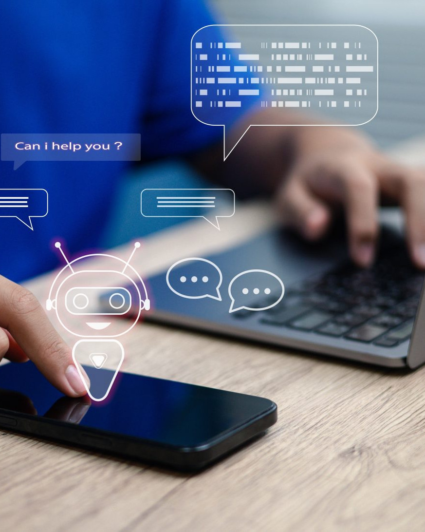 Man using laptop and phone to interact with chatbots for customer support and digital communication.