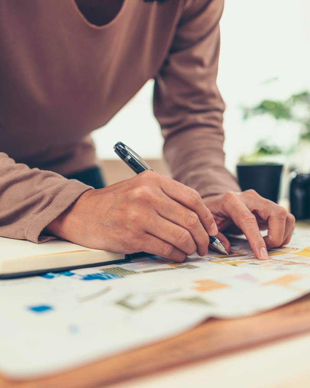 Person reviewing design plans and notes while developing a creative strategy